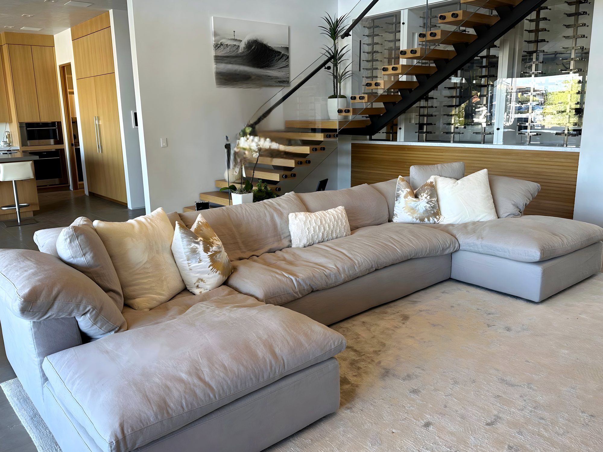 Living room with floating oak staircase and glass wine wall
